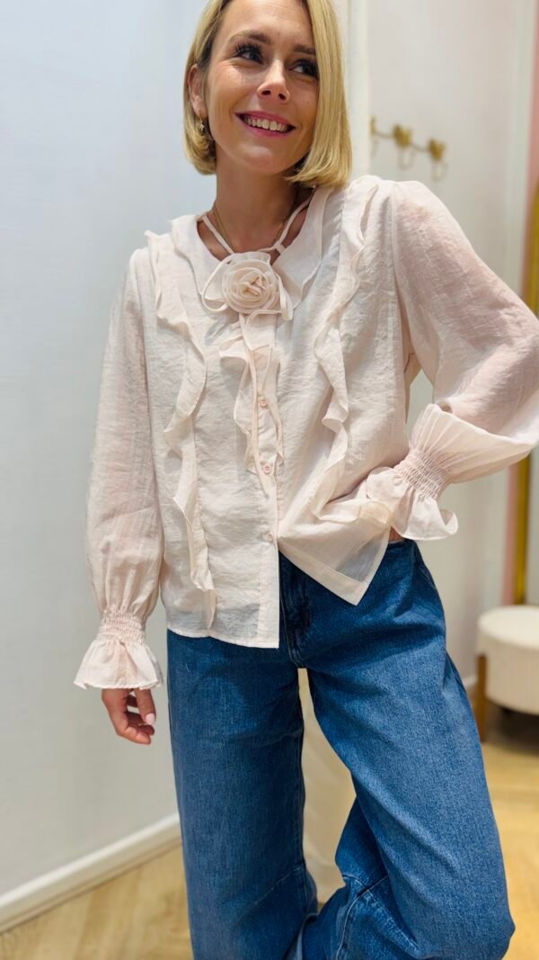 Blouse rose à volant avec broche fleurs